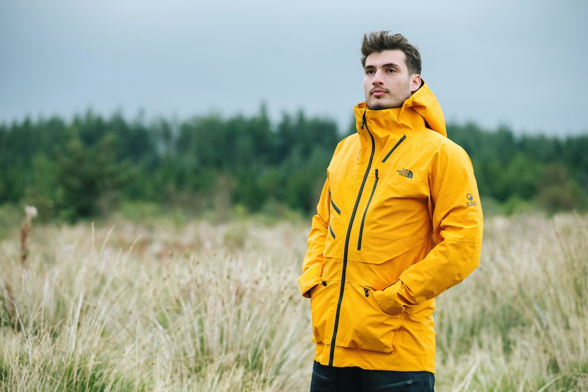 Мужчина в желтой куртке The North Face Summit Series